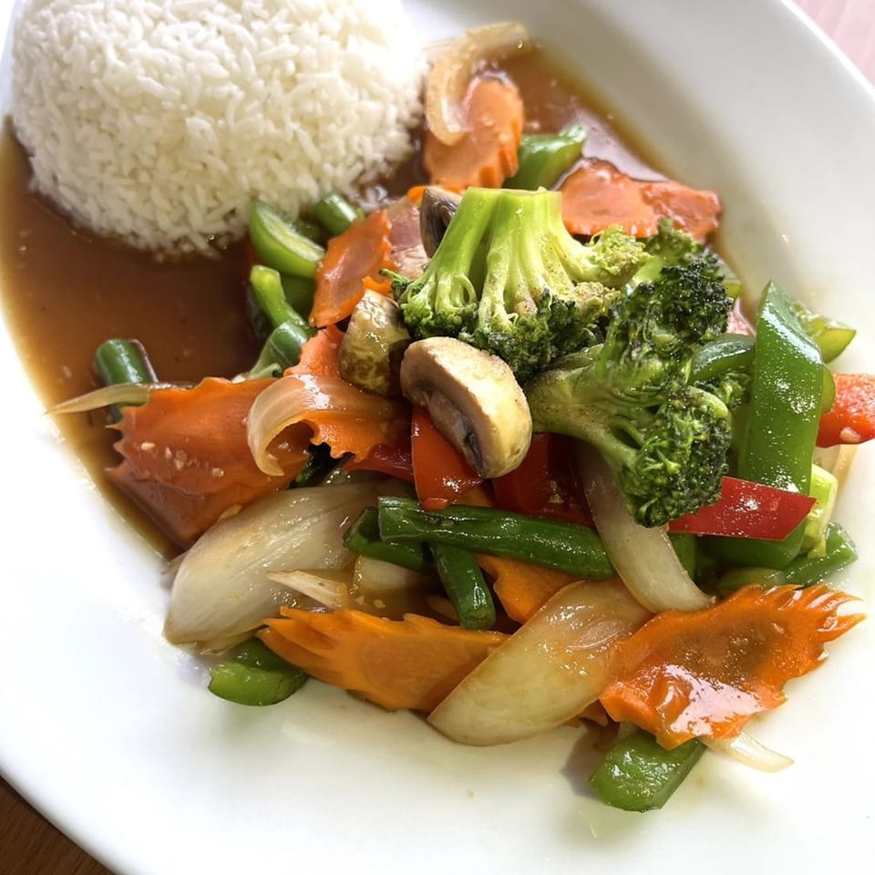 Origin Thai Bistro's stir-fried mixed vegetables with white rice on a white plate.