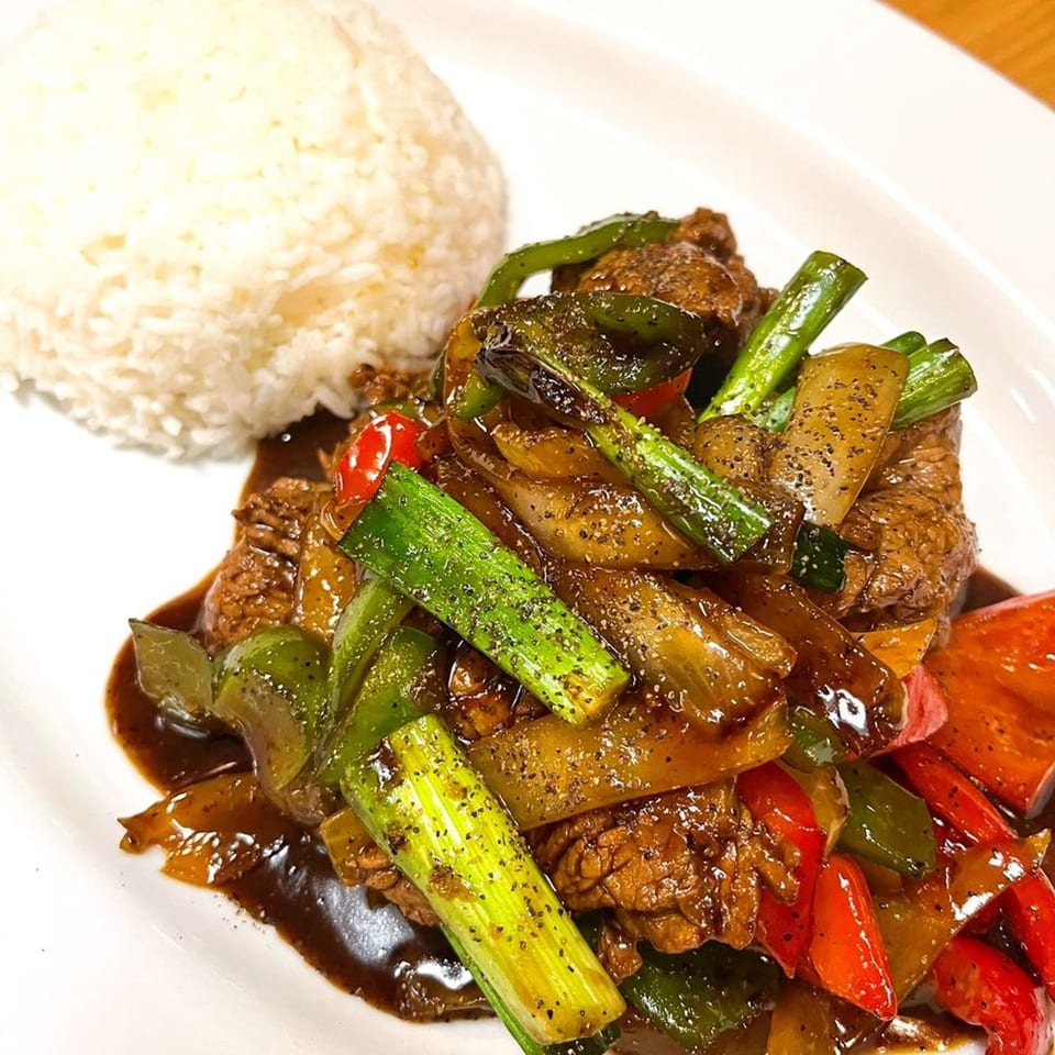 Origin Thai Bistro's black pepper beef with bell peppers, onions, and scallions, served with white rice.